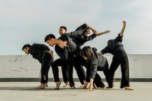 A group of adults performing dynamic contemporary dance on a rooftop.